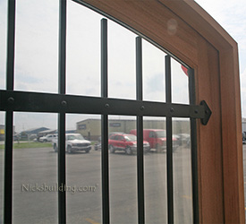 custom arched double doors with iron bars closeup